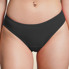 Black bikini underwear worn by a person on a beige background