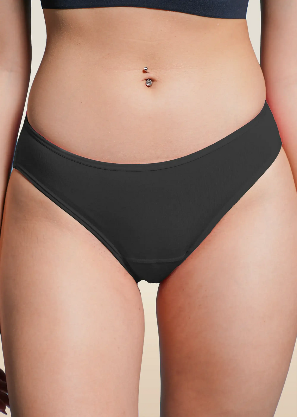 Black bikini underwear worn by a person on a beige background