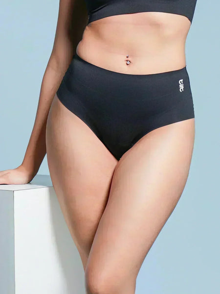 Person wearing black mid-waist underwear on a light blue background