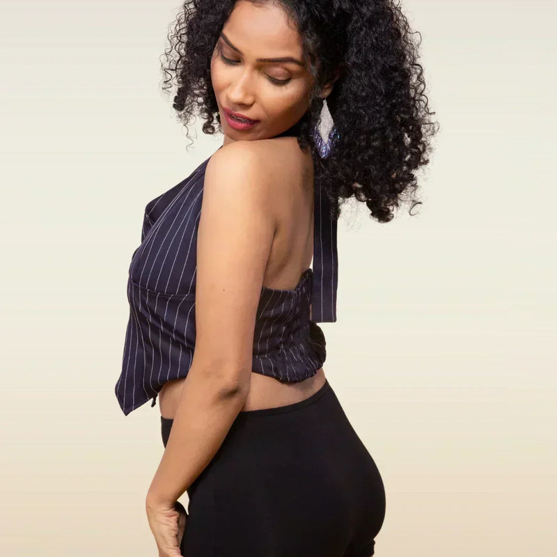 Woman wearing a striped top and black boyshorts against a beige background