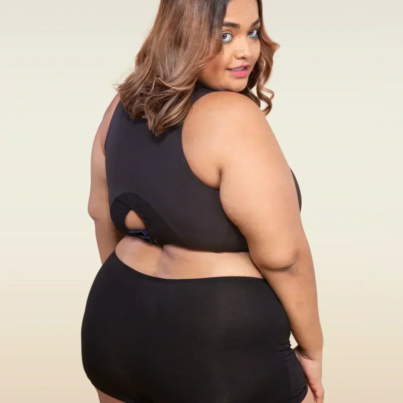 Woman wearing a black top and  boyshort on a beige background
