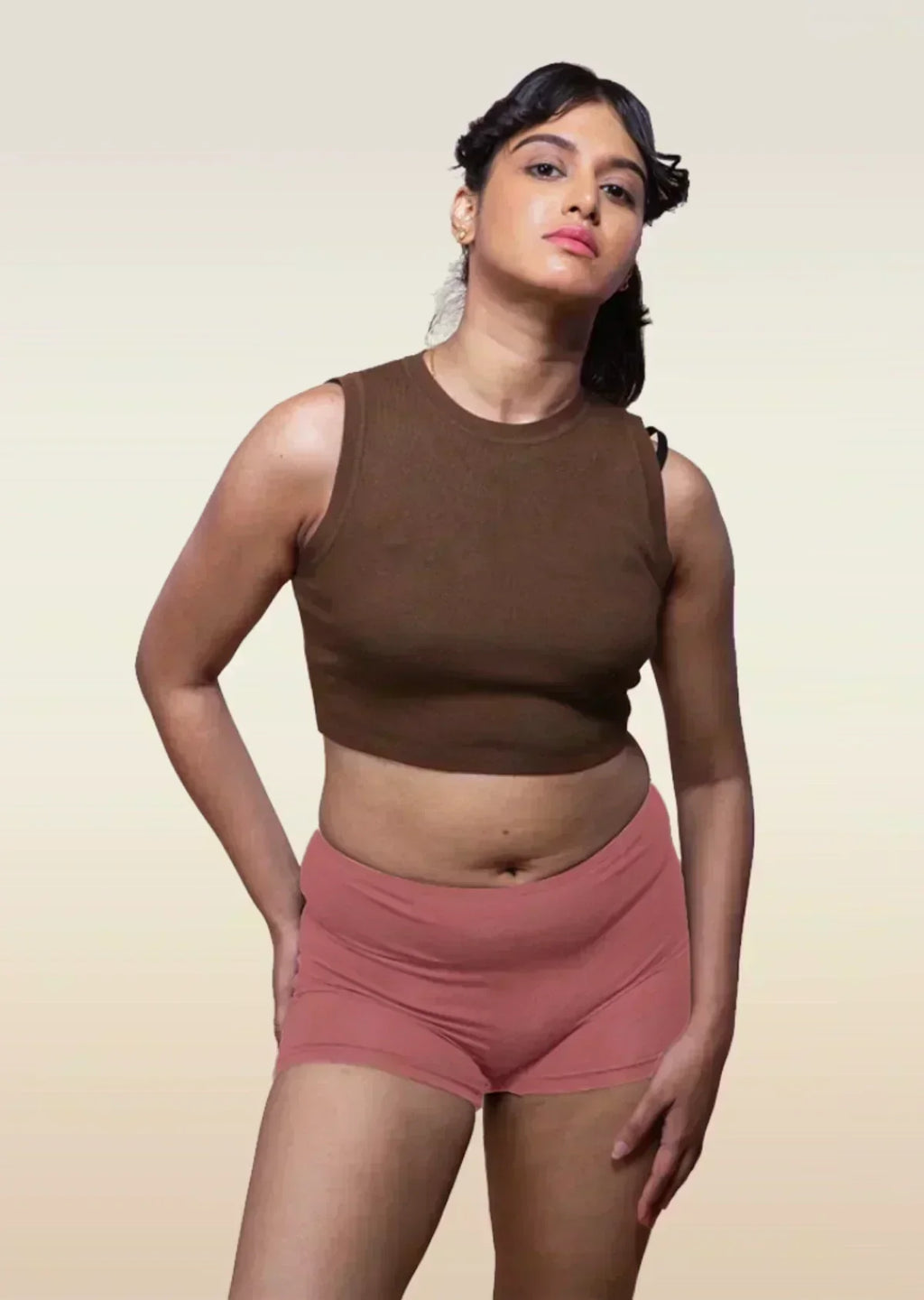 person wearing a brown sleeveless crop top and red boyshort style underwear.