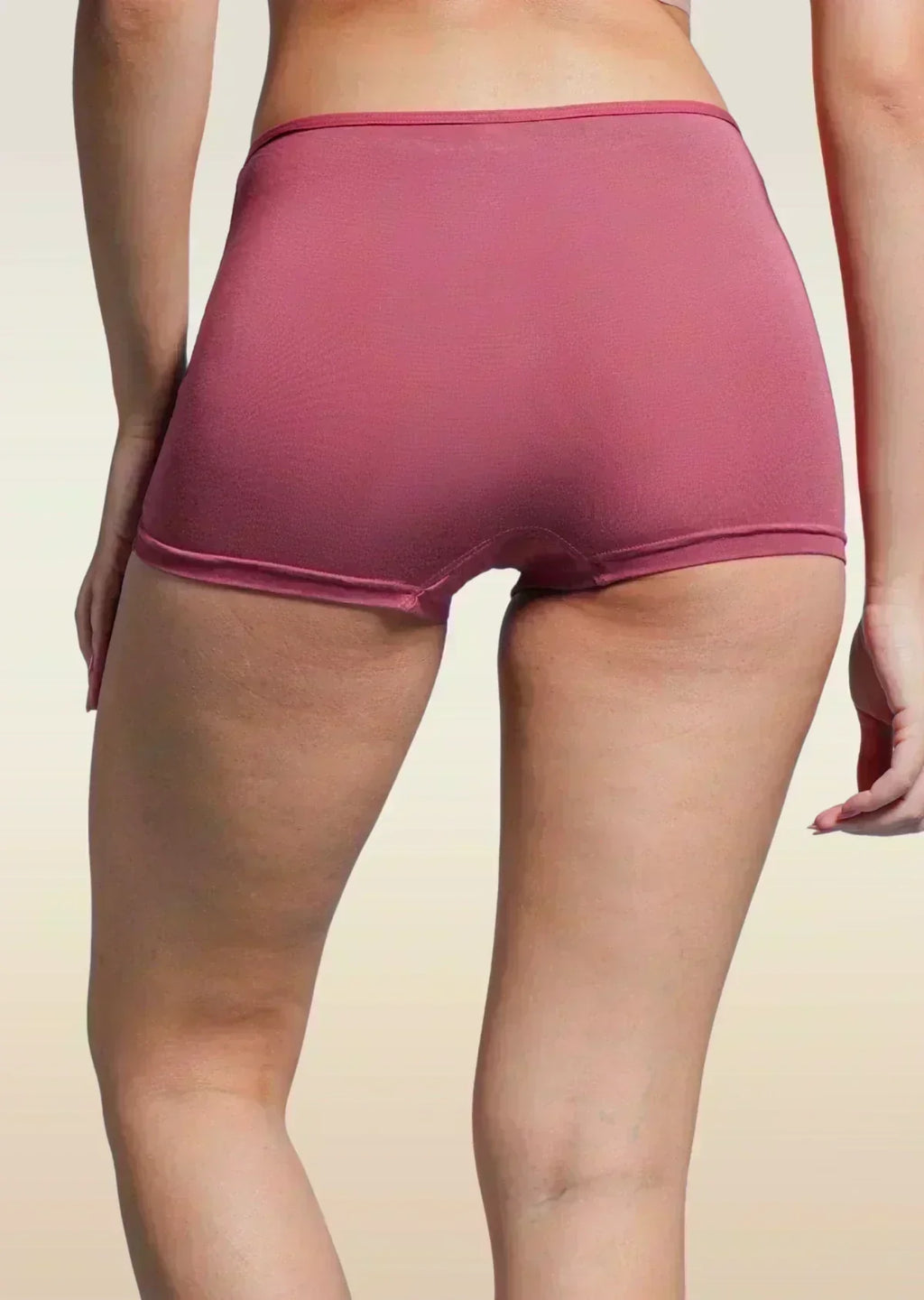 Person wearing a red boyshort on a beige background