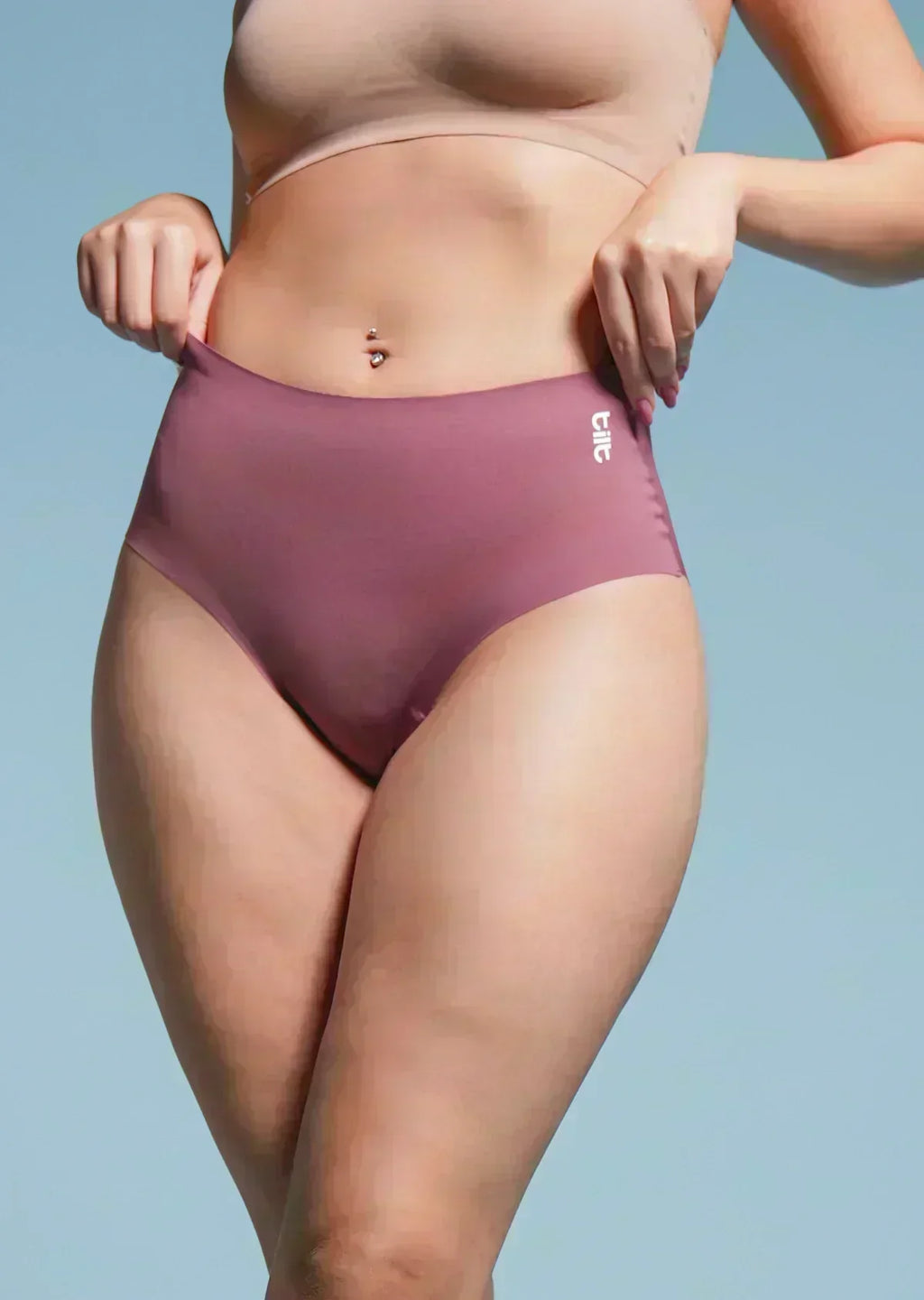 Person wearing a pair of rose gold underwear with a light blue background