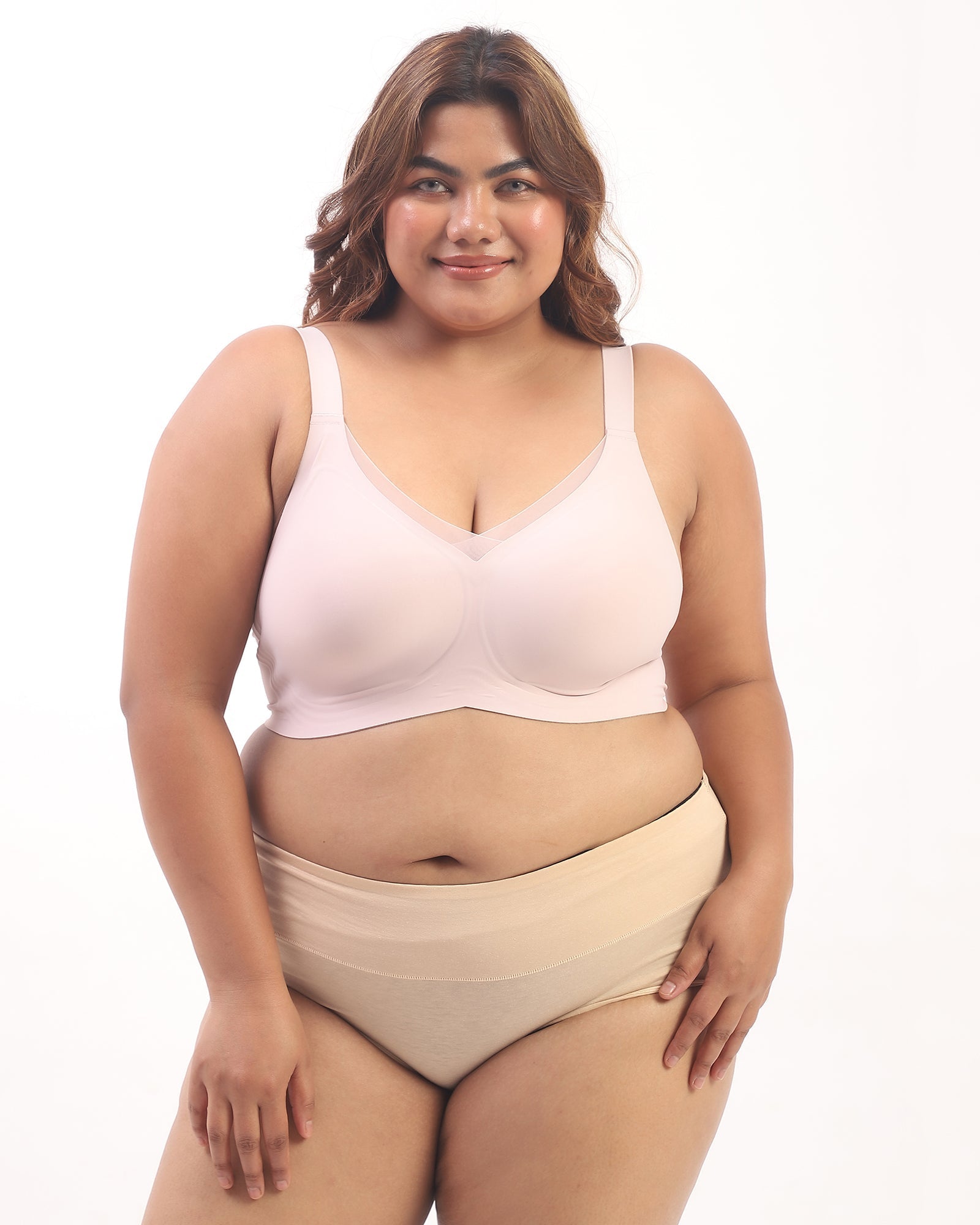 Woman wearing a beige bra and panties set on a white background