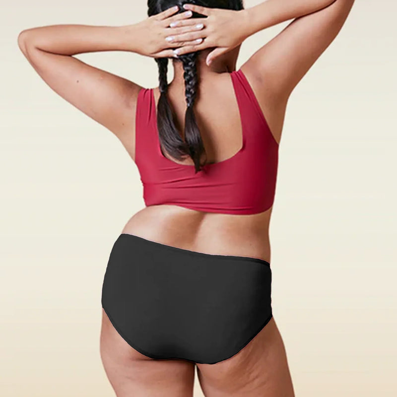 Person wearing a red sports bra and black high-waisted underwear on a beige background
