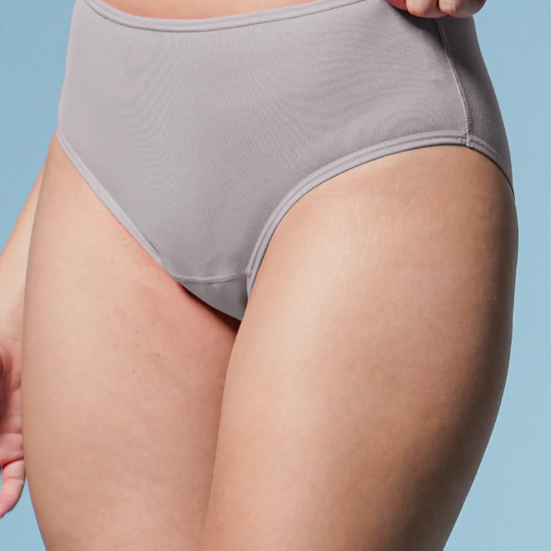 Person wearing gray underwear against a light blue background