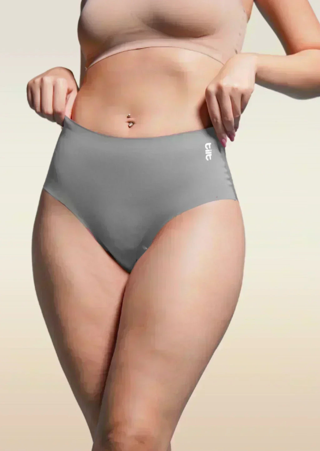 Person wearing gray underwear with a beige background