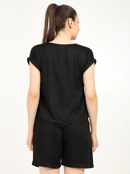Back view of a woman wearing a black women's modal satin night suit with shorts and a relaxed fit.