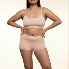 Woman wearing a beige bra and boyshorts on a beige background