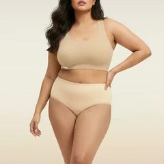 Woman wearing beige bra and  underwear set on a plain background