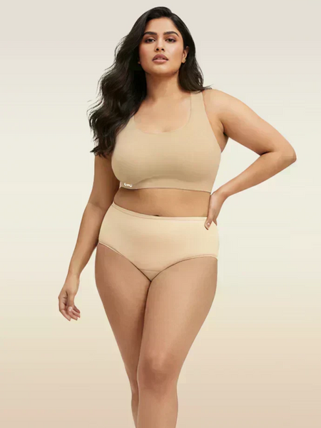 Woman wearing beige bra and  underwear set on a plain background