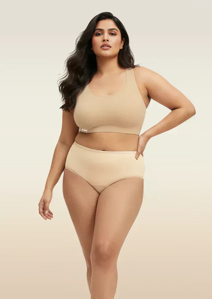 Woman wearing beige bra and  underwear set on a plain background