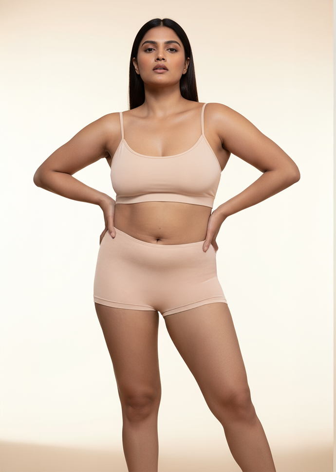 Woman wearing a beige bra and  boyshorts on a beige background
