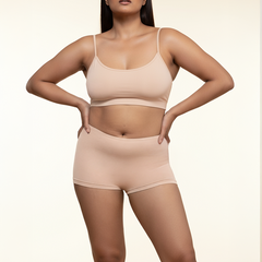 Woman wearing a beige bra and  boyshorts on a beige background