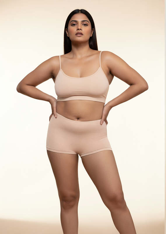 Woman wearing a beige bra and  boyshorts on a beige background