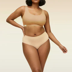 Woman wearing a beige bra and underwear set on a beige background