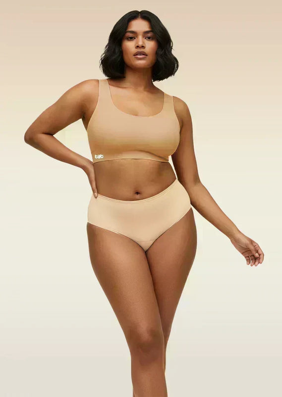 Woman wearing a beige bra and underwear set on a beige background