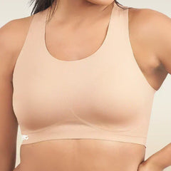 Beige sports bra worn by a person on a plain background