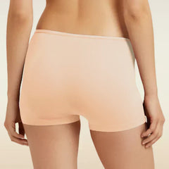 Person wearing a beige colored boyshorts on a beige background