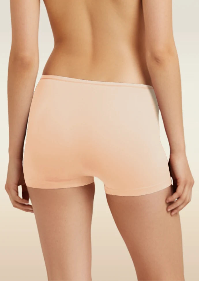 Person wearing a beige colored boyshorts on a beige background