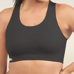 Woman wearing a black sports bra with a visible brand logo on a neutral background