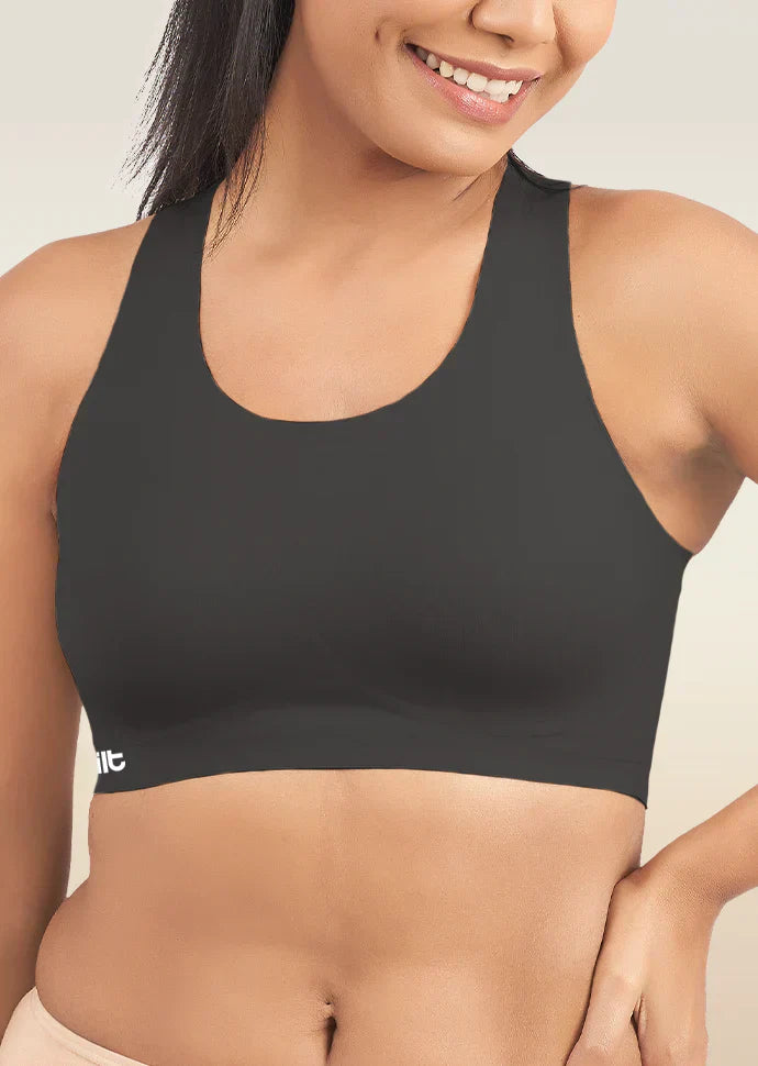 Woman wearing a black sports bra with a visible brand logo on a neutral background