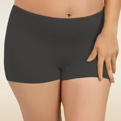 Black mid-waist boyshort underwear worn by a person on a beige background