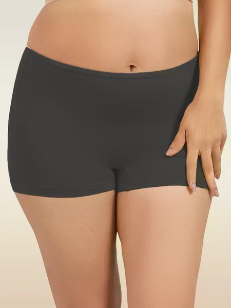Black mid-waist boyshort underwear worn by a person on a beige background