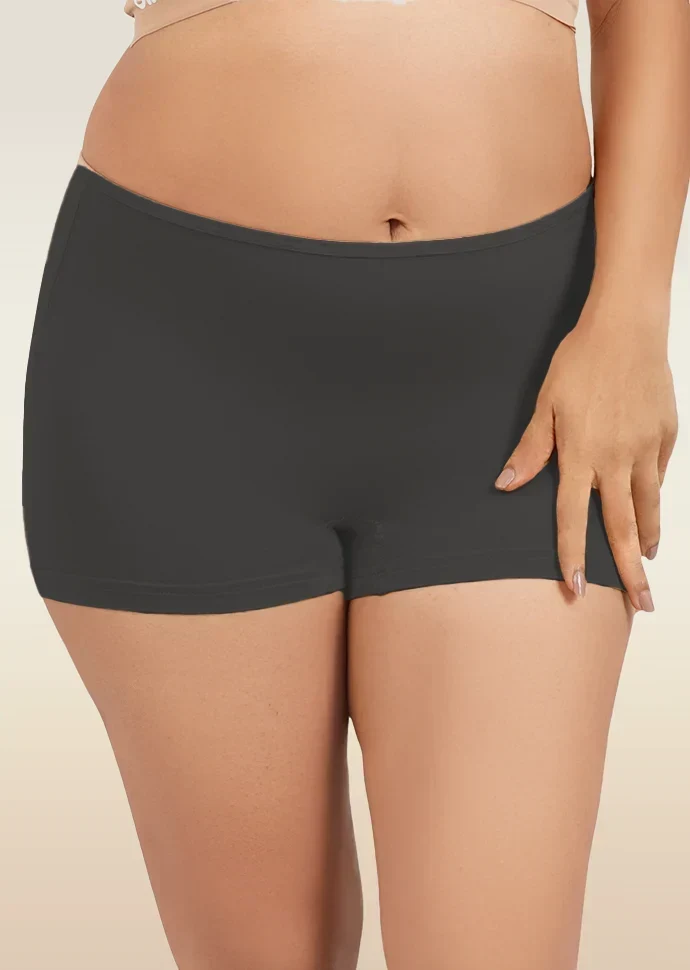 Black mid-waist boyshort underwear worn by a person on a beige background