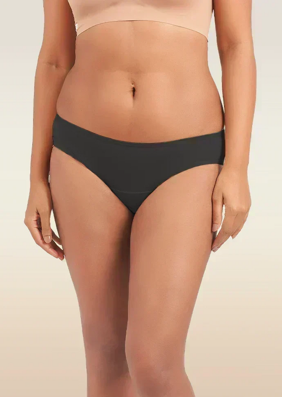Person wearing black underwear on a beige background