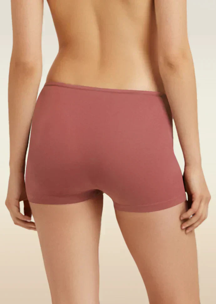 Person wearing a red boyshorts underwear on a beige background