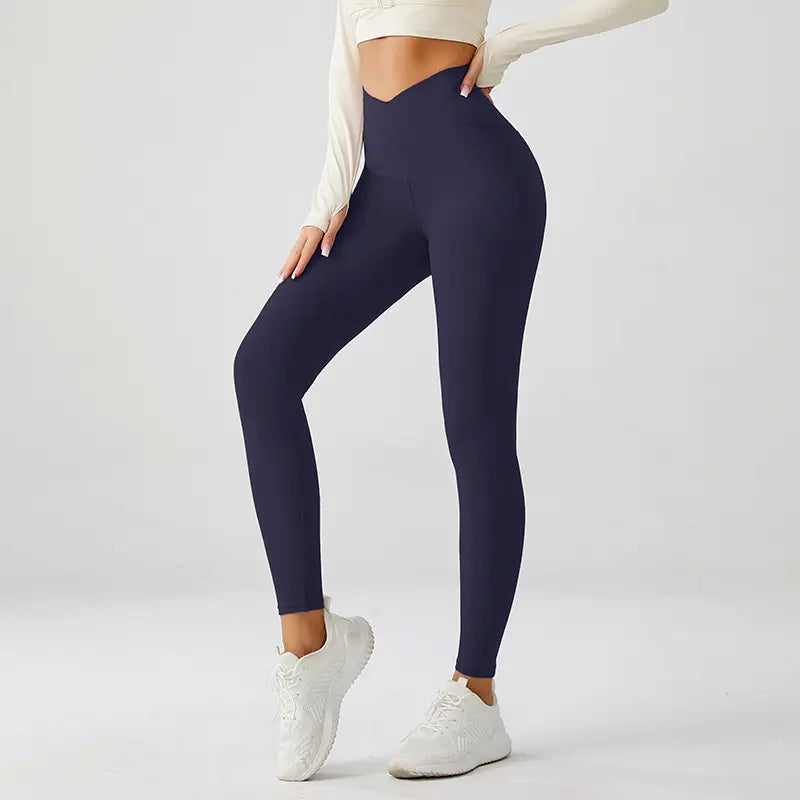 Person wearing xfyt navy leggings and white sneakers on a light gray background